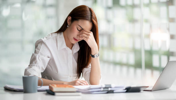 istock Young Asian businesswoman working on laptop computer, stressed has a headache and thinks hard from work at the office. 1388179507