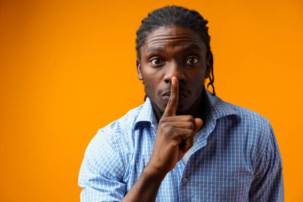istock African-American man showing silence gesture over yellow background 1388179743