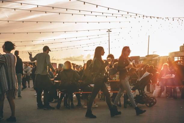 paisaje de festival de música, gente hermosa caminando bajo la luz de fondo - fiesta callejera fotografías e imágenes de stock