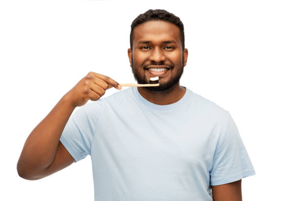 istock smiling african man with toothbrush cleaning teeth 1388182575