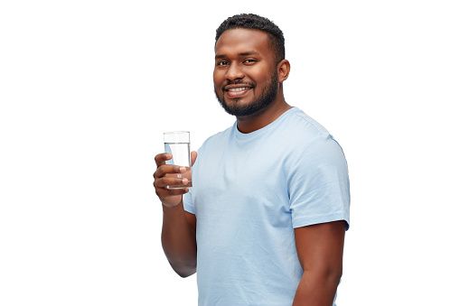 healthy eating, diet and people concept - happy smiling african american man with glass of water over white background