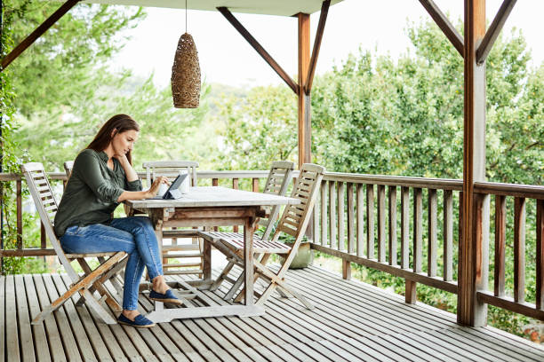 istock Woman using digital tablet in balcony at home 1388182909