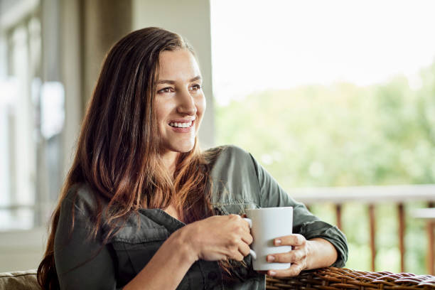 istock Smiling woman looking away while having coffee 1388182938
