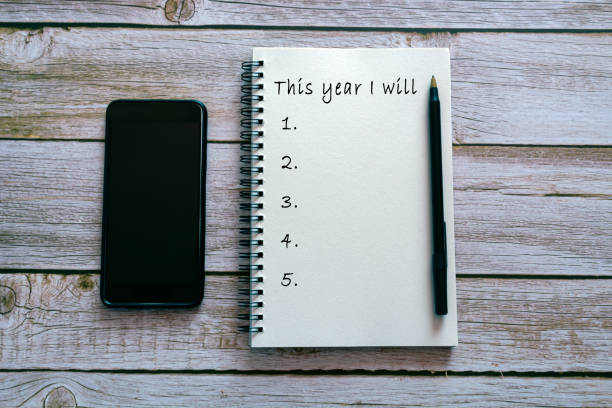 istock This year I will text on notepad on wooden background with smartphone and pen. 1388183066