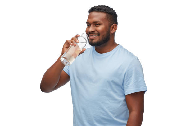 istock happy african man drinking water from glass bottle 1388184462