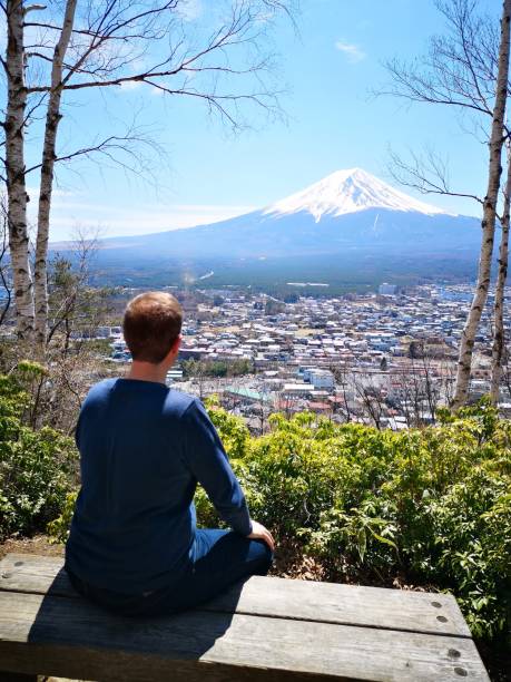 Tourist man enjoying the view of Mt fuji from Kawaguchiko Tenjozan Park