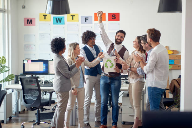 istock Group of young environmentally focused employees recycling together 1388184965