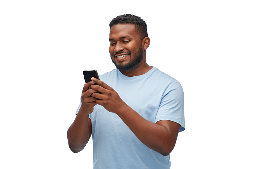 technology and people concept - happy young african american man with smartphone over white background