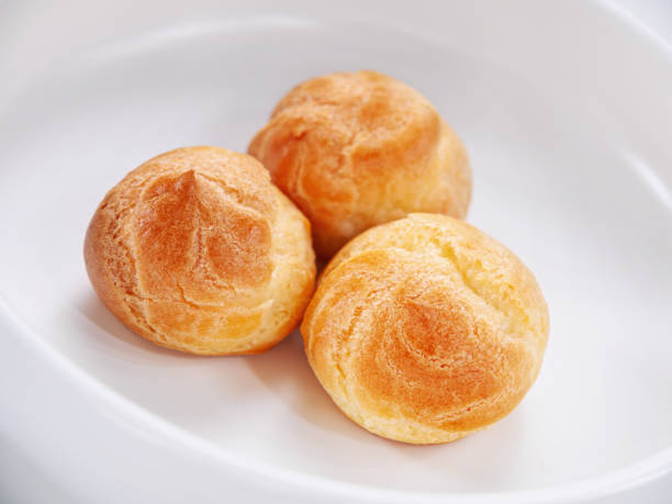 istock Fresh baked profiteroles on the white plate. 1388186113