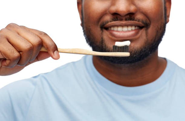 istock smiling african man with toothbrush cleaning teeth 1388186215