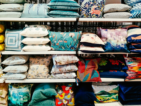 Large selection of cushions with different designs on display and for sale in the store.