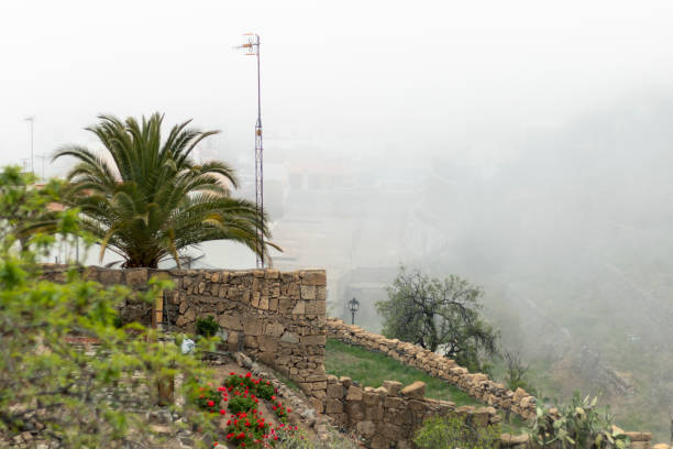 Background picture with small village of the Tenerife, Canary islands, ,Vilaflor terraces with flowers and palma tree in the morning fog Background picture with small village Tenerife, Canary islands,Vilaflor terraces with flowers and palma tree in the morning fog village vilaflor on tenerife stock pictures, royalty-free photos & images