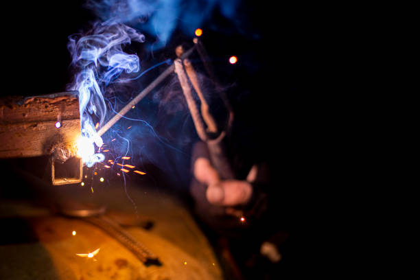 istock welder working on a metal structure fixing an urgent problem on the night shift close-up, front and back background blurred with bokeh effect 1388187056
