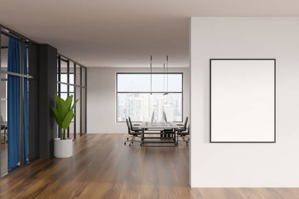 istock Modern office room interior, desktop computers on table, beige walls. Hardwood floor. Panoramic city view windows. White empty framed poster template. Concept of international coworking. 3d rendering 1388188322