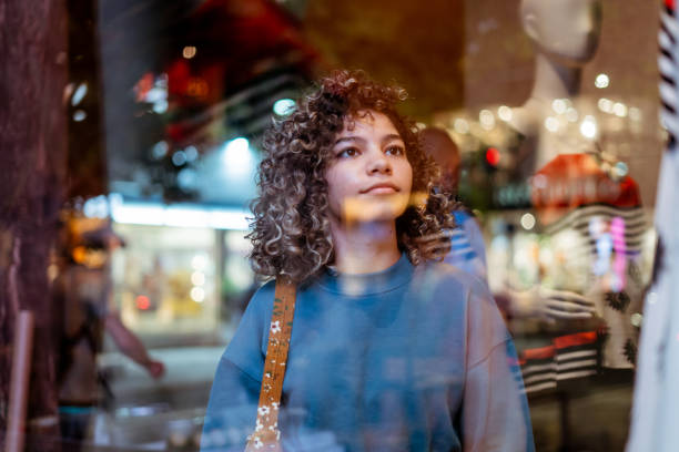Young woman looking at clothing store At night, casual clothes, window-shopping window shopping stock pictures, royalty-free photos & images