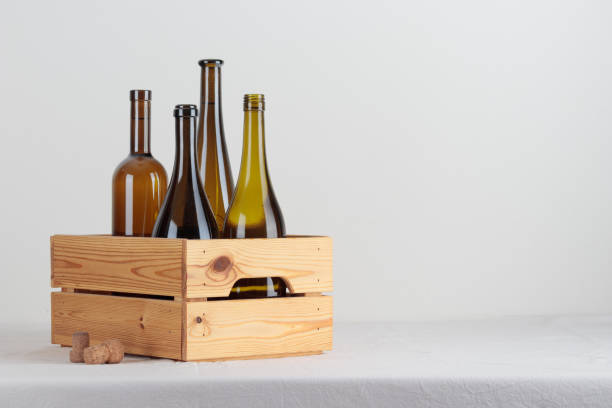 istock Green wine bottles in the box on the white table 1388190519