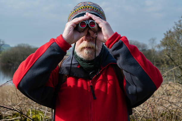 istock Close up front view of a senior man using binoculars 1388192643