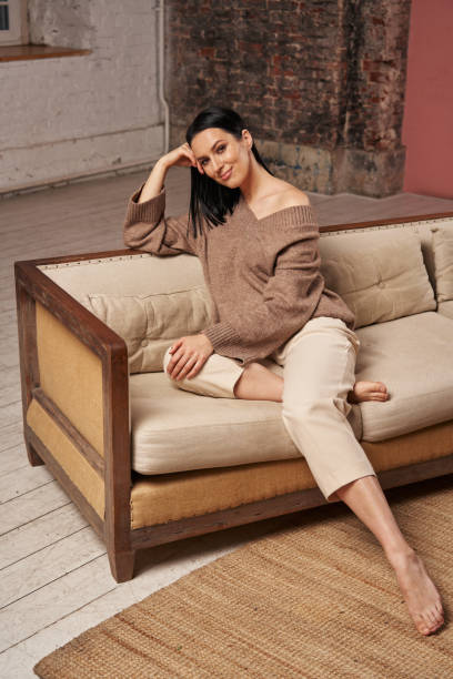istock young woman sitting on a cozy sofa in a large room 1388192649