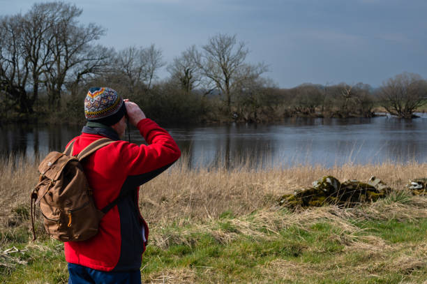 istock Senior man using binoculars in a rural location 1388192781