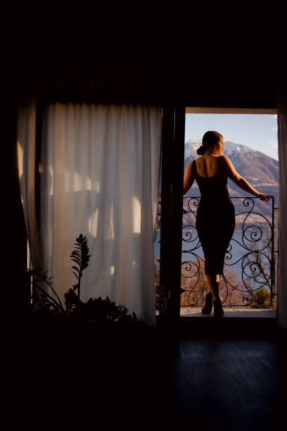 istock Young woman relaxes on balcony, over lake 1388192813