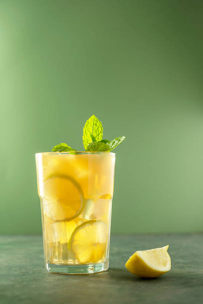 limonade mit frischer minze und eiswürfeln im glas. erfrischendes sommergetränk. grüner hintergrund. - zitronensaft stock-fotos und bilder