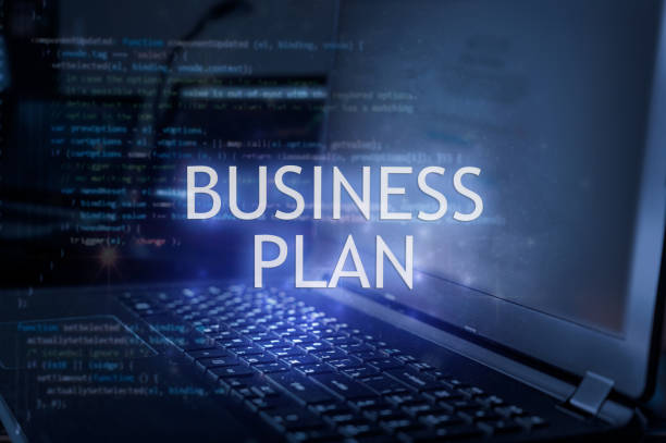istock Business plan inscription against laptop and code background. 1388196347