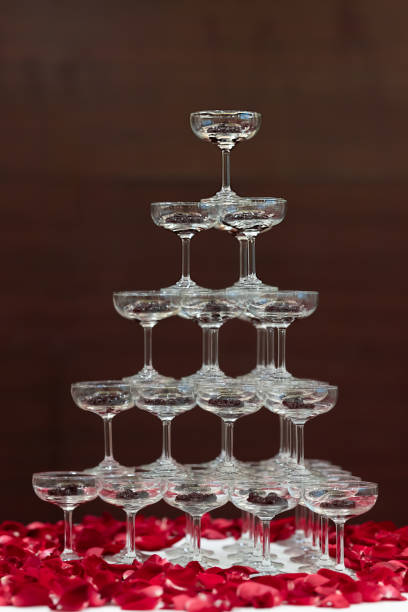 perle di tapioca in champagne vetro piramide torre decorata con petali di rosa su tavolo di stoffa bianca - luxury milk dinner glass foto e immagini stock