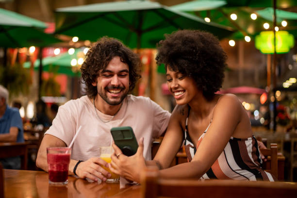 istock Couple using cell phone in the city 1388199745