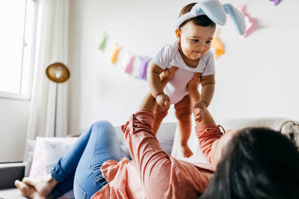 mother and her baby celebrating easter at home - spring happiness women latin american and hispanic ethnicity imagens e fotografias de stock