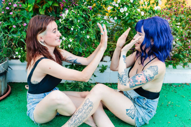 istock Happy young women playing patty cake in backyard 1388201095