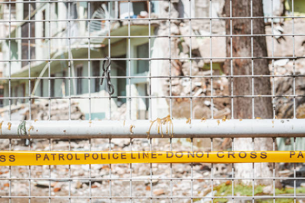 ruban jaune avec ligne de police ne pas croiser l’inscription devant le bâtiment détruit - quake damaged section photos et images de collection
