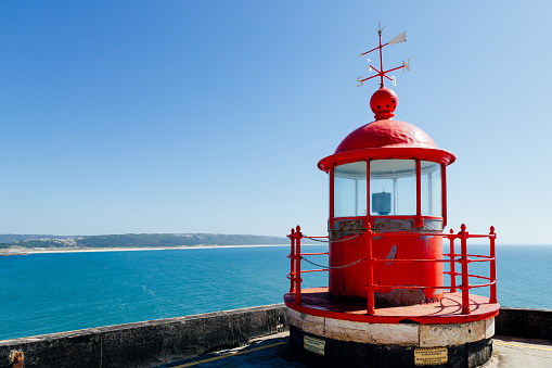 Red lighthouse on the Sao Miguel fort in NazarÃ©, Portugal, a privileged observatory for the wave season