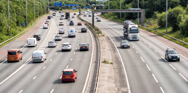 Daytime traffic on the M6 Motorway Traffic on a curving section of the M6 motorway in the West Midlands of England. car point of view stock pictures, royalty-free photos & images