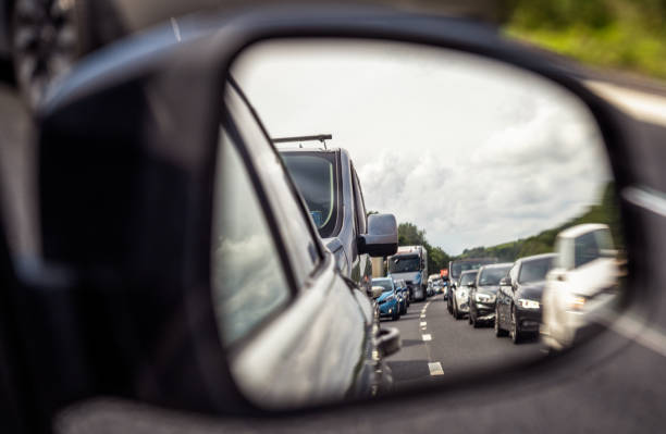 Looking back at traffic jam A view in a car's wing mirror showing a dual carriageway filled up with a traffic jam on a busy day. rear view mirror stock pictures, royalty-free photos & images