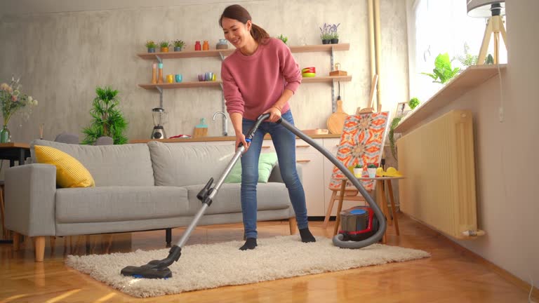 Young woman with vacuum cleaner in the living room