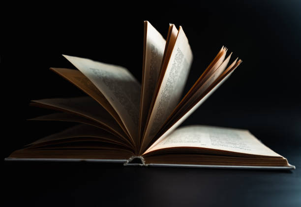 istock Open book, hardcover books on a dark background. 1388202803
