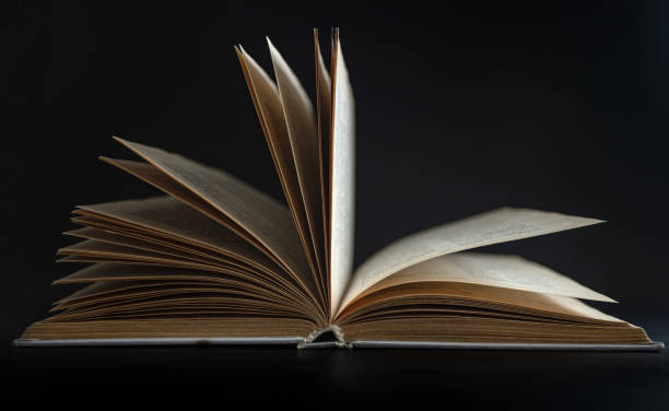 istock Open book, hardcover books on a dark background. 1388202869