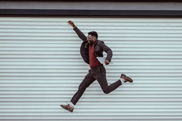 happy young businessman jumping - saltando imagens e fotografias de stock