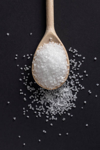 istock Wooden spoon with salt on a dark background 1388204840