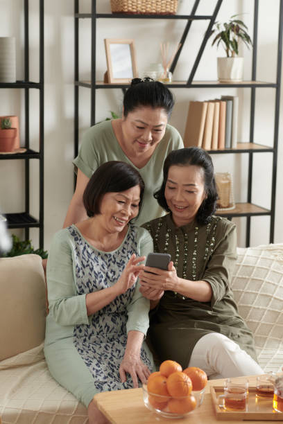 istock Senior Friends Watching Funny Videos 1388206926