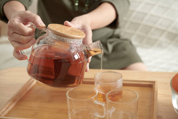 istock Woman Pouring Tea in Cups 1388206928