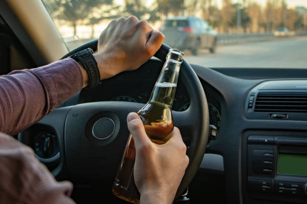 istock Man drinking beer while driving a car. Don't drink and drive concept. 1388208489
