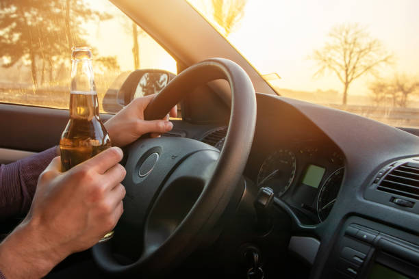 istock Man drinking alcohol while driving in his car on sunset 1388208537