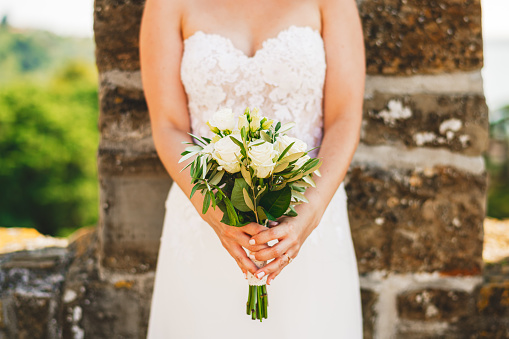 Bride holding white roses and olive branch wedding bouquet