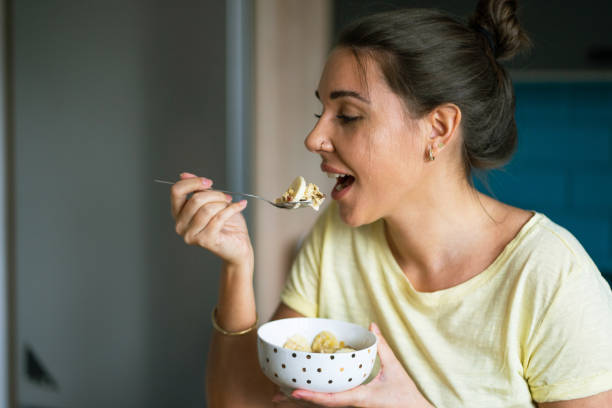 istock Young woman eating breakfast in the kitchen 1388209917
