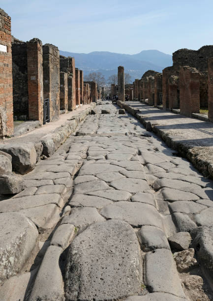 Carved tracks in a road in the Roman city of Pompeii Carved tracks in a road in the Roman city of Pompeii on a sunny day pompeii ruins stock pictures, royalty-free photos & images