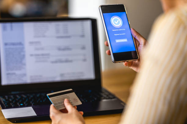 istock Young woman Paying Bills with mobile phone 1388210664