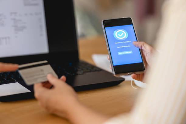 istock Young woman Paying Bills with mobile phone 1388210666