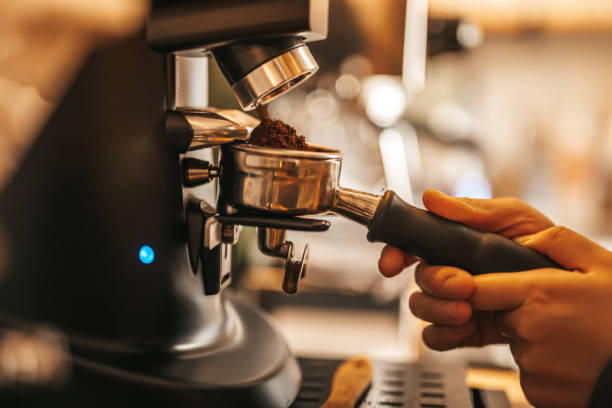 frisch gemahlener kaffee wird in einer siebträgermaschine vertikal verarbeitet - cappuccino coffee bean bean espresso stock-fotos und bilder