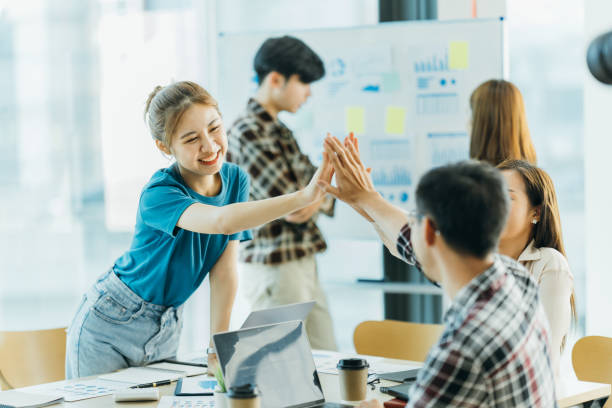 istock happy employees giving each other a high five. 1388211062